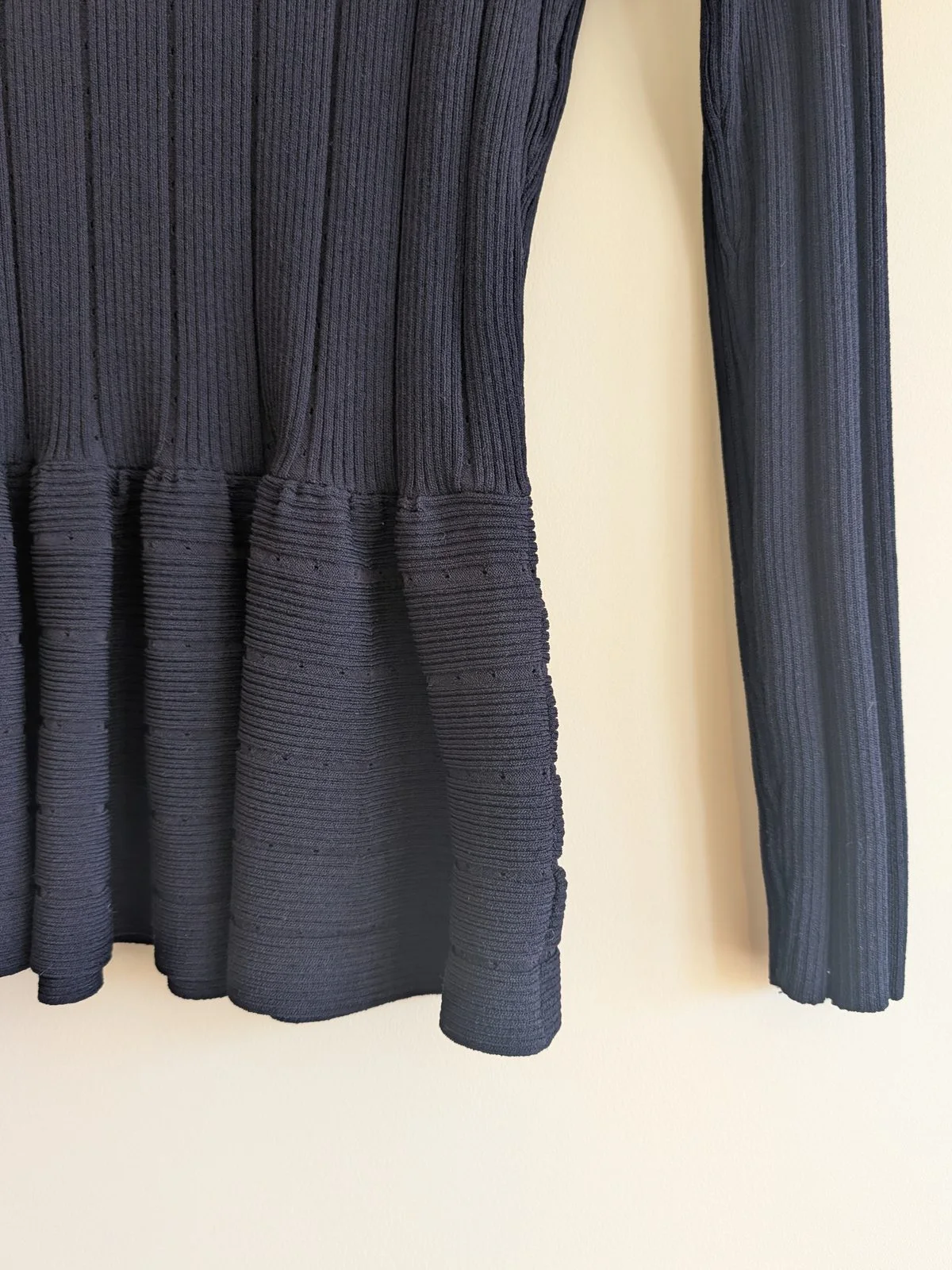 Close view of the peplum hem and right sleeve